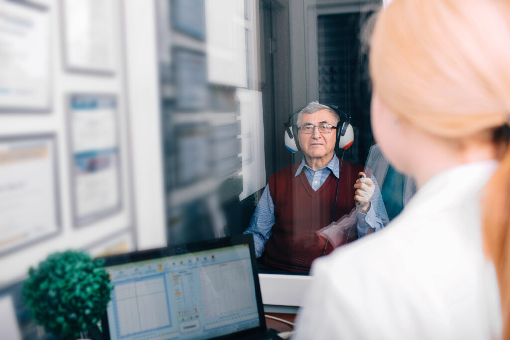 senior patient having hearing exam in special audio room Senior man getting a hearing test at a doctors office, audiometer hearing test