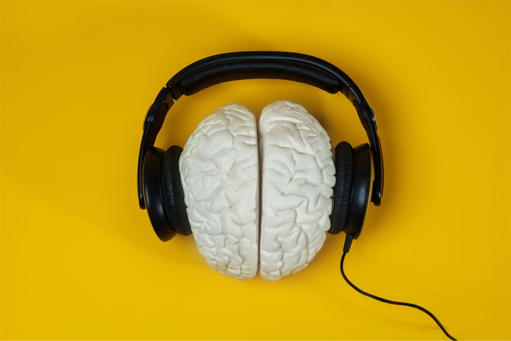 Brain-with-Headphones Headphones on the brain over yellow background